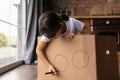 Close up little girl playing pirate, drawing on cardboard box Royalty Free Stock Photo