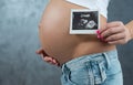 Close up of a cute pregnant belly and ultrasound scan of baby. Royalty Free Stock Photo