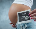 Close up of a cute pregnant belly and ultrasound scan of baby Royalty Free Stock Photo