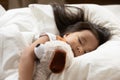 Close up cute serene Asian little girl hugging toy, sleeping Royalty Free Stock Photo