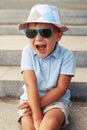 Close-up of cute small boy in sunglasses and hat with excited fa Royalty Free Stock Photo