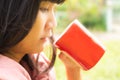 Close up cute woman holding red cup for drinking hot coffee tasty in morning outdoor. happy lifestyle vacation in holidays. Royalty Free Stock Photo