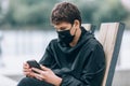 Close up cute young boy with black protective mask on face. Teenager wearing medical mask to protect from corona virus, illness Royalty Free Stock Photo