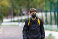 Close up cute young boy with black protective mask on face. Teenager wearing medical mask to protect from corona virus, illness, Royalty Free Stock Photo