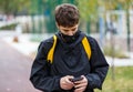 Close up cute young boy with black protective mask on face. Teenager wearing medical mask to protect from corona virus, illness, Royalty Free Stock Photo