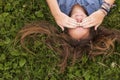 Close-up cute young long-haired girl lying on the green grass . Royalty Free Stock Photo