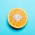 Close-up of cutted orange fruit isolated on background of cyan color. Royalty Free Stock Photo