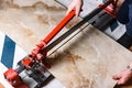 Close up of cutting ceramic tile with red manual tile cutter. Royalty Free Stock Photo