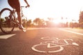 Close up cycling logo image on road with athletic women cyclist legs riding Mountain Bike in background at the morning