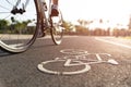 Close up cycling logo image on road with athletic women cyclist legs riding Mountain Bike in background at the morning