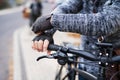 A close-up of a cyclist with electrobike putting on gloves outdoors in town. Royalty Free Stock Photo