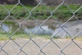 Close up of cyclone fence with river in background