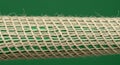 A close-up of a cylindrical object wrapped in a beige, coarse-fibered netting. The Royalty Free Stock Photo