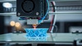 Close-up of a 3D printer creating a blue geometric object Royalty Free Stock Photo