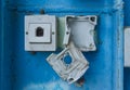 Damaged Electrical Outlet on Blue Wall Royalty Free Stock Photo