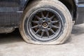 Close-up Of A Damaged Flat Tire Of A Car On The Road. Old wheel car dirty and flat tires. Car tire puncture. Royalty Free Stock Photo