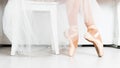 Close-up of dancing legs of ballerina wearing white pointe on a white background