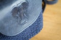 Close-up of a dark blue knitted bag with a leather insert and an elephant print on a light wooden surface. Workplace in the Royalty Free Stock Photo