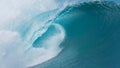 CLOSE UP: Dark blue tube wave rages towards the spectacular coast of Tahiti.