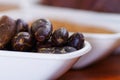 Close up of a dark dry cocoa bean inside of a white bowl Royalty Free Stock Photo