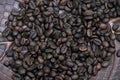 A close-up of dark roasted coffee beans piled on a brown. Royalty Free Stock Photo