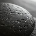 A close-up of a dark, smooth stone with a textured surface. The stone appears Royalty Free Stock Photo
