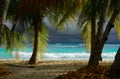 CLOSE UP: Dark stormy skies span above the turquoise ocean washing sandy beach Royalty Free Stock Photo