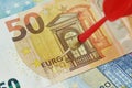 Close-up of dart arrow with euro banknotes