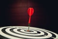 Close-up Dart board with arrow hitting in center.