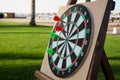 Close up of darts with red and green arrows on green grass background. Darts game on vacation. Funny game for tourist on the beach Royalty Free Stock Photo