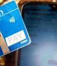 Close up of a debit or credit card making online payment through mobile phone to pay bills