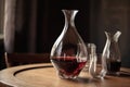 close-up of decanter with wine and glasses on wooden table