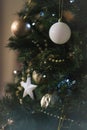 Close up of a decorated christmas tree with golden and white balls and stars. Vertical photography. Blurred background Royalty Free Stock Photo