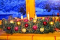 Close-up of a decorated garland from the branches of a New Year tree with Christmas decorations and lit candles.