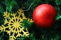 Closeup decoration hanging on Christmas tree branches by red bauble ball, golden snowflake Royalty Free Stock Photo