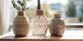 Close up of decorative jars and vase decoraed with Macrame knotting on wooden table. Home decor and accent pieces