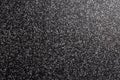 Close up of decorative quartz sand epoxy coated floor or wall coating with grey and black coloured particles. Side lighted