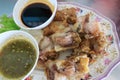 Close-up of deep-fried pork knuckle with dipping sauces and sauces, a popular Thai local dish.