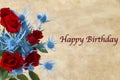 A Close-up of Deep Red Roses with Alpine Sea Holly and Happy Birthday on the Right side of the Image.