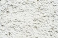Close-up Deep texture of white-painted porous stone on the facade of the building. Stoned wall background texture Royalty Free Stock Photo