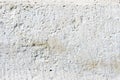 Close-up Deep texture of white-painted porous stone on the facade of the building. Stoned wall background texture Royalty Free Stock Photo