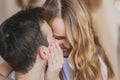 Close up defocused portrait of young attractive romantic couple hugging and kissing, laying down on a bed, being loving with each Royalty Free Stock Photo