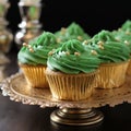 Close-up Delicious appetizing cupcakes with green cream and sprinkles.