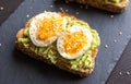 Close-up of delicious avocado toast topped with sliced boiled eggs and sesame seeds