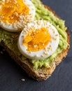 Close-up of delicious avocado toast topped with sliced boiled eggs and sesame seeds