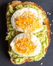 Close-up of delicious avocado toast topped with sliced boiled eggs and sesame seeds