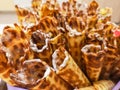 Close-up of delicious chocolate waffle rolls lie on white plate. Preparation of a sweet dessert. White clean kitchen and table. Royalty Free Stock Photo