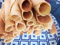 Close-up of delicious chocolate waffle rolls lie on white plate. Preparation of a sweet dessert. White clean kitchen and table. Royalty Free Stock Photo