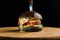 Close-up of delicious fresh home made beef burger with lettuce, cheese, onion and tomato. Hangs a corner of cheese Royalty Free Stock Photo