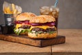 Close-up of delicious fresh home made burger with lettuce, cheese, onion and tomato on a rustic wooden board. Also fries with ketc Royalty Free Stock Photo